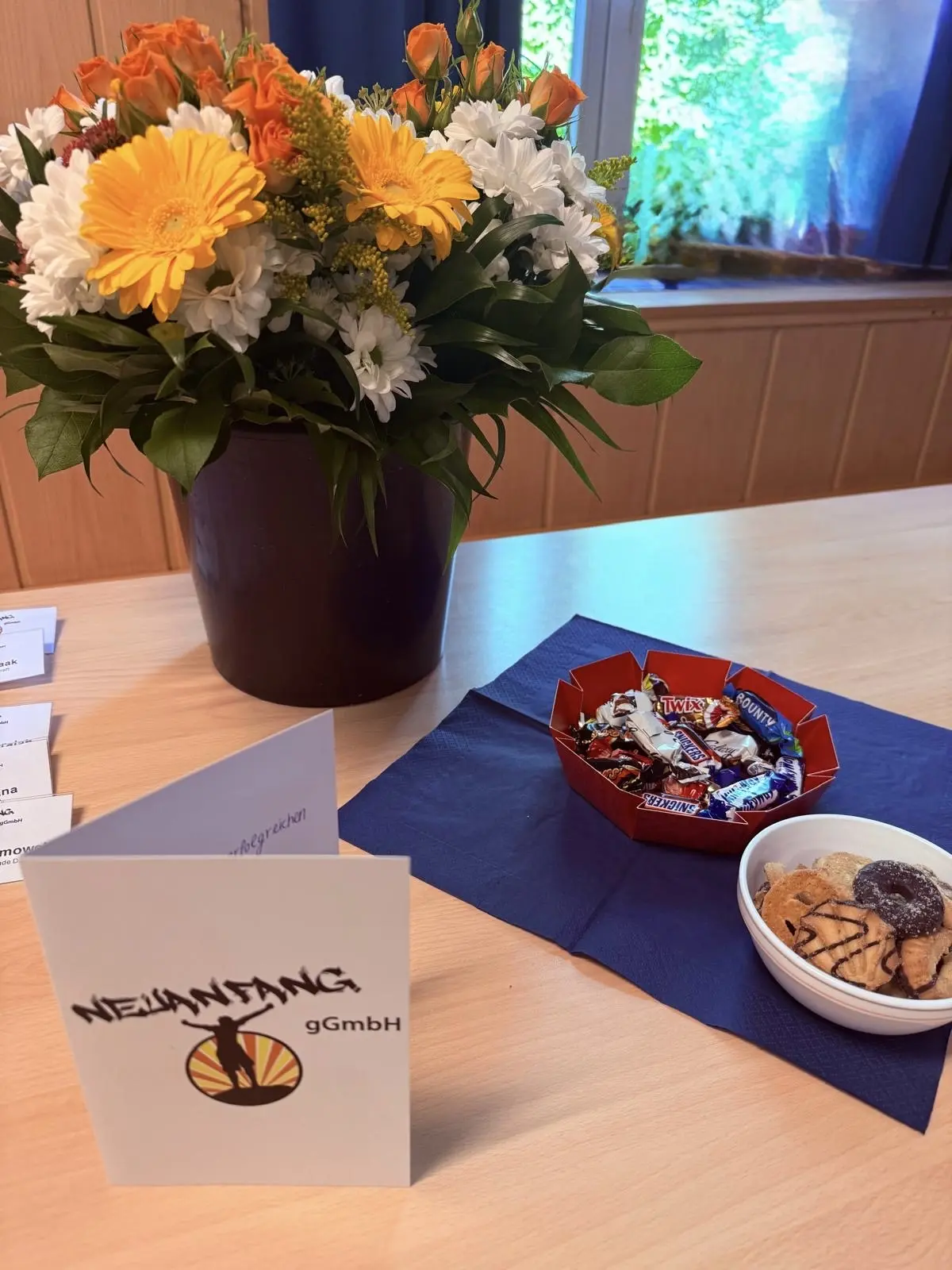 Ein Blumenstrauß mit bunten Blumen und eine Schüssel mit Snacks auf einem Tisch.