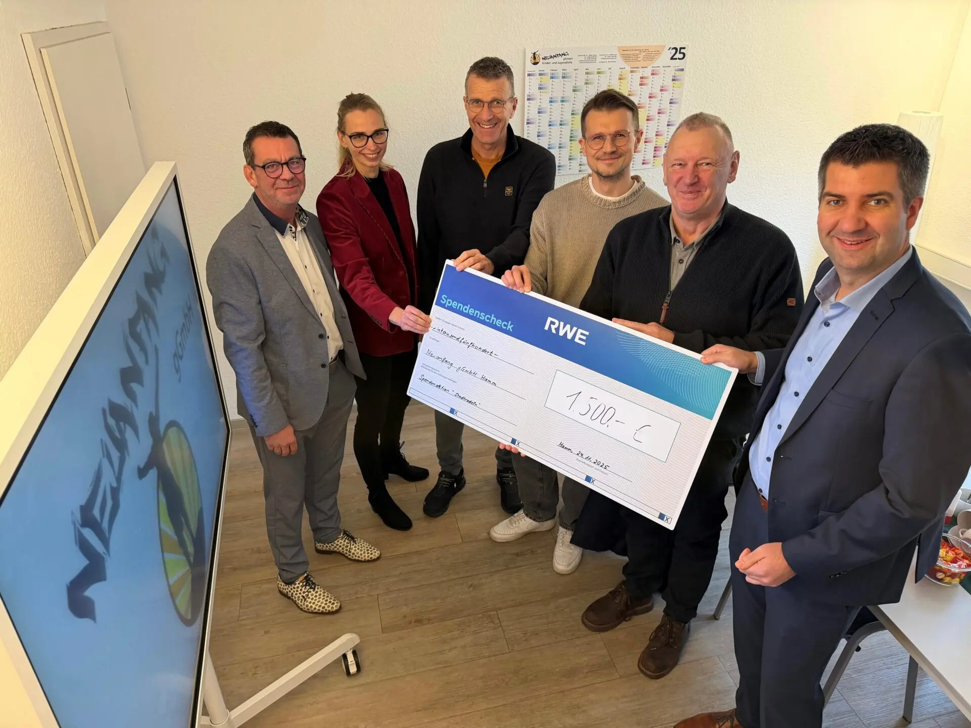 Gruppe von sechs Personen, die einen großen Scheck über 1500 Euro von RWE präsentieren.